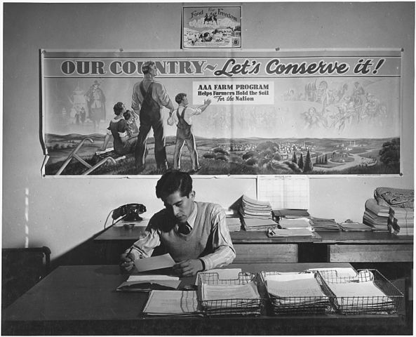 An Agricultural Adjustment Administration representative in his office, Taos County, New Mexico, December 1941. The agency was created under the New Deal to reduce farm surpluses and manage production. Irving Rusinow